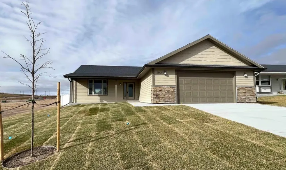 Single-story Monument home with a landscaped lawn and two-car garage